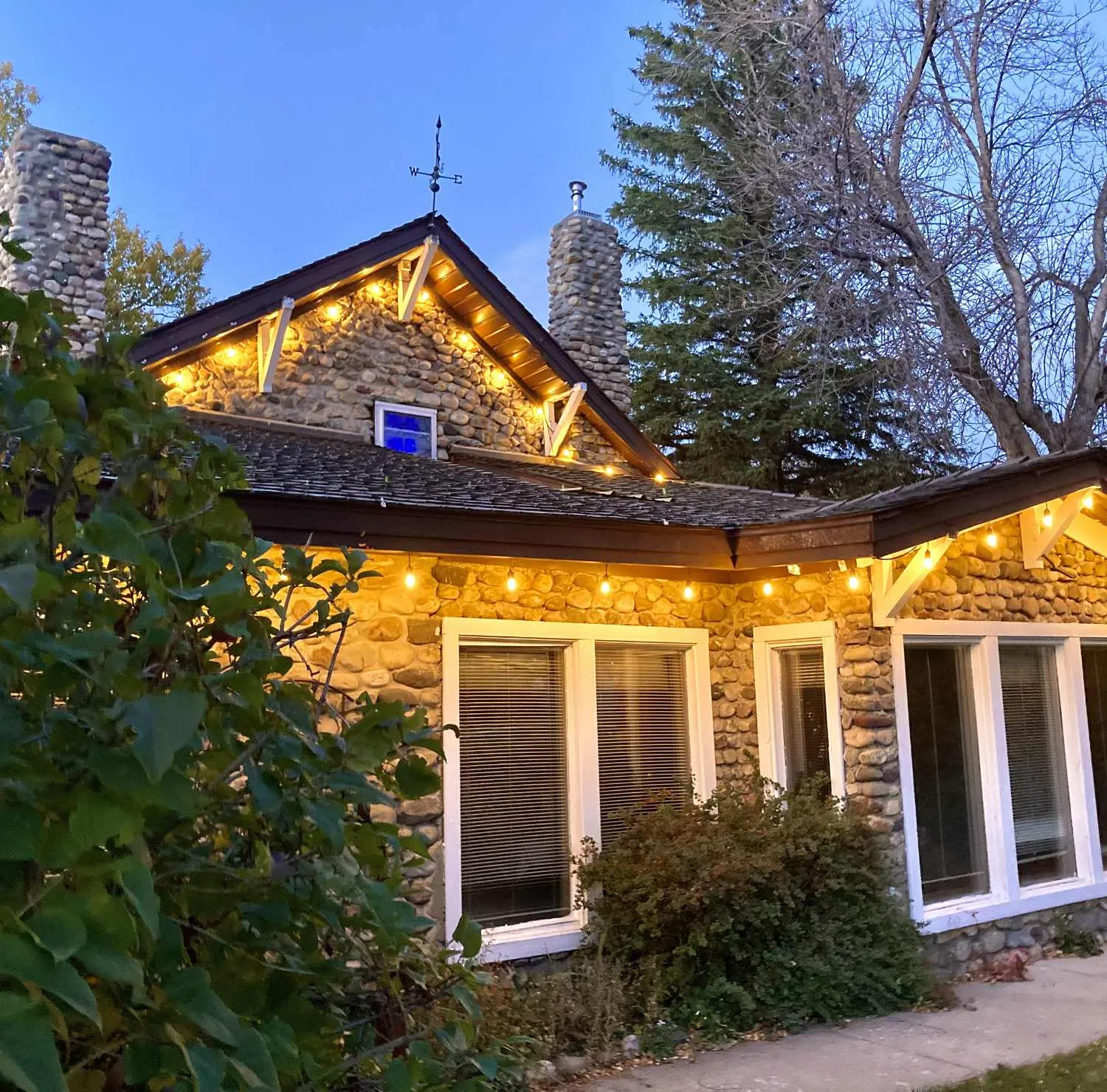 The stone manor lit up at dusk