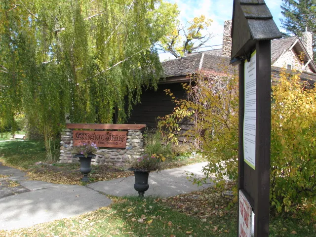 Willow trees and the Cobblestone Manor sign at the entrance
