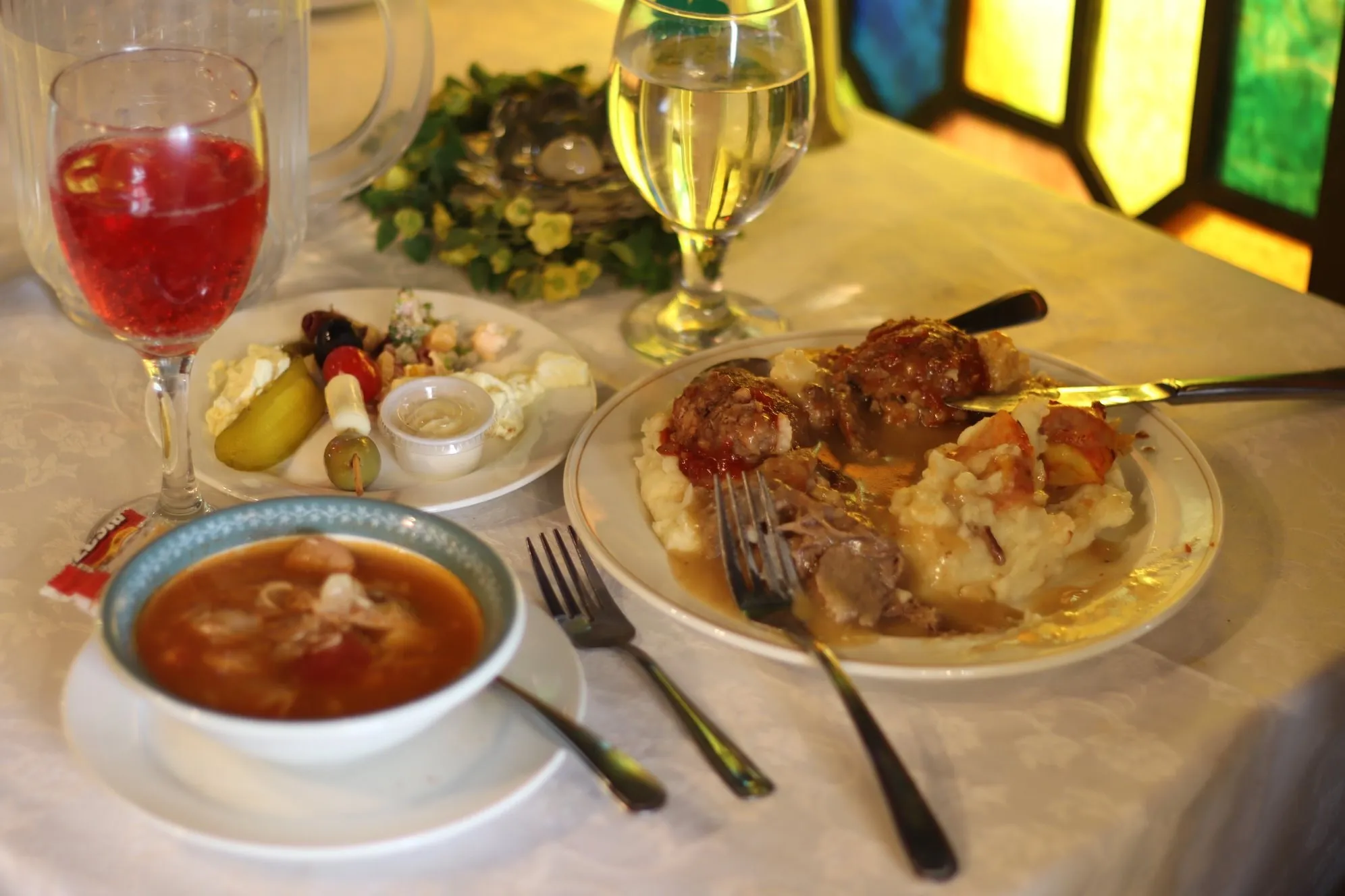 A plated dinner with soup in the Stained Glass Room